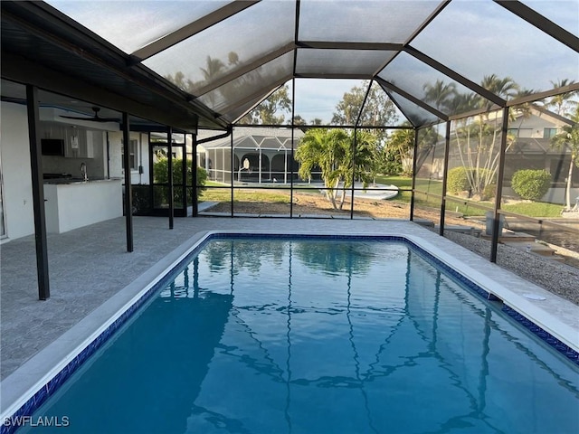 view of pool featuring a lanai, an outdoor bar, and a patio area