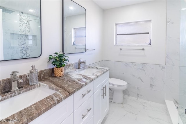 bathroom with vanity, tile walls, and toilet