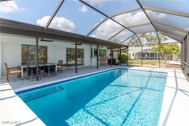 view of pool with a lanai, a patio, ceiling fan, and exterior bar