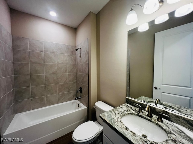 full bathroom with tiled shower / bath, vanity, and toilet