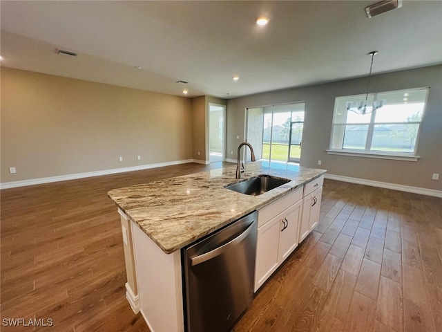 kitchen featuring sink, dishwasher, white cabinetry, a center island with sink, and decorative light fixtures