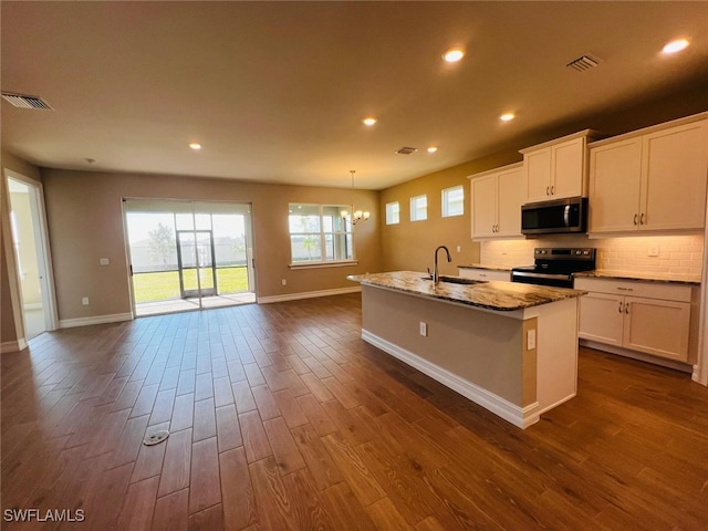 kitchen featuring white cabinetry, sink, a kitchen island with sink, and electric range