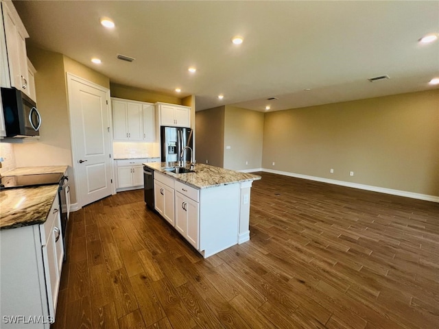 kitchen featuring sink, appliances with stainless steel finishes, a kitchen island with sink, light stone countertops, and white cabinets