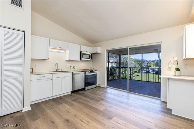 kitchen featuring appliances with stainless steel finishes, light hardwood / wood-style floors, sink, and white cabinets