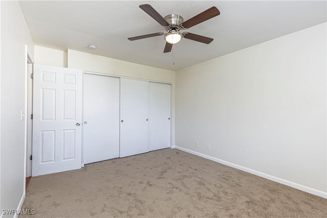 unfurnished bedroom featuring light carpet, a closet, and ceiling fan