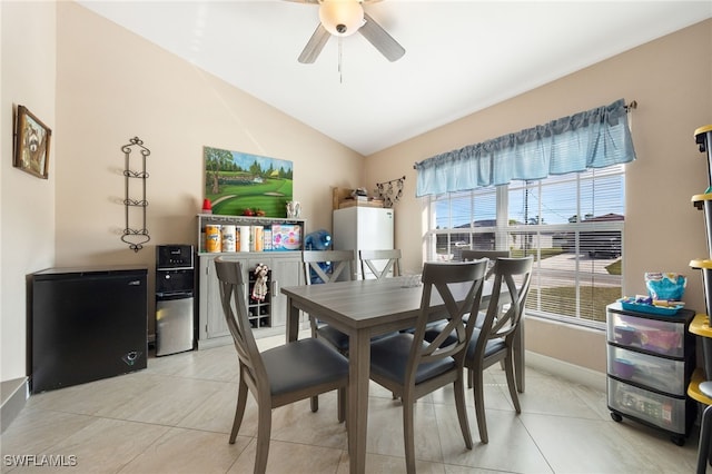 dining room with vaulted ceiling, ceiling fan, and light tile patterned flooring