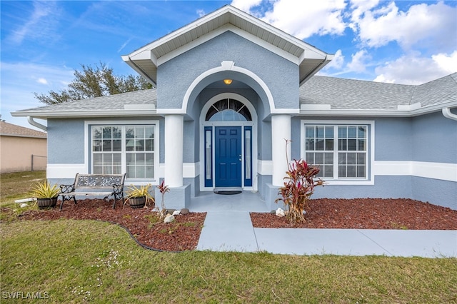 property entrance featuring a lawn