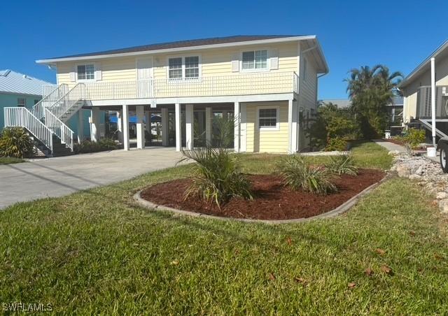 rear view of property featuring a carport and a yard