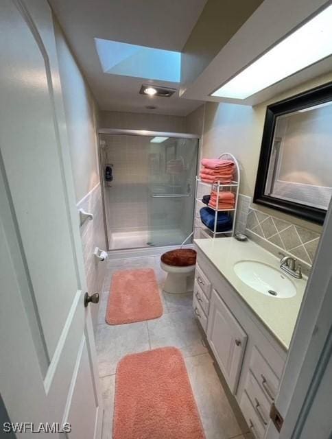 bathroom with a shower with door, tile patterned flooring, vanity, decorative backsplash, and toilet