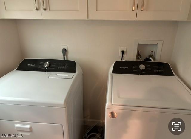 clothes washing area featuring cabinets and washer and dryer