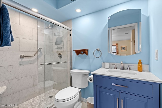 bathroom with vanity, toilet, and a shower with shower door