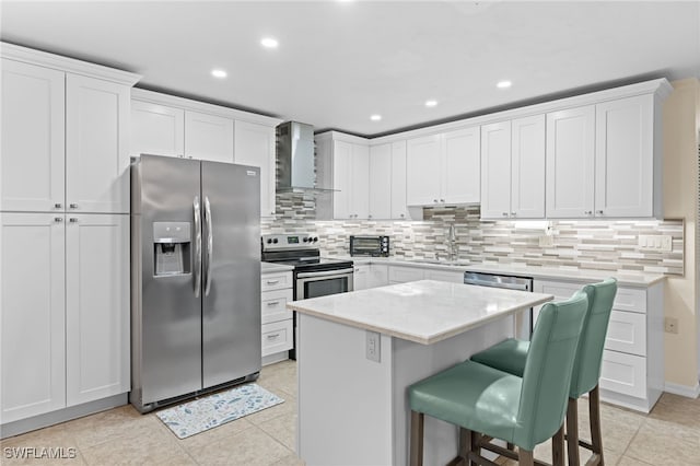 kitchen featuring white cabinets, stainless steel appliances, and wall chimney exhaust hood