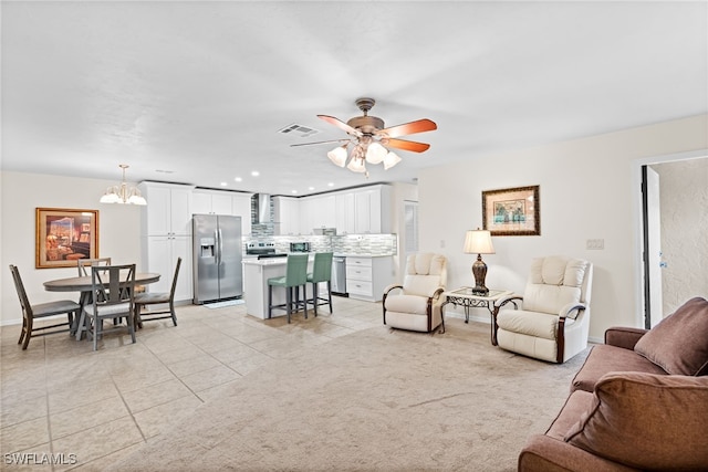 carpeted living room with ceiling fan with notable chandelier