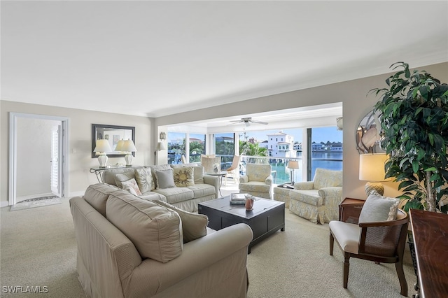 living room featuring a water view, light colored carpet, and ceiling fan