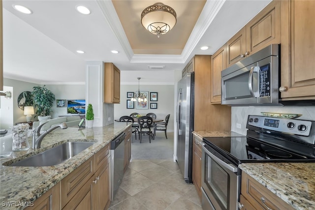 kitchen featuring stainless steel appliances, crown molding, sink, and a tray ceiling