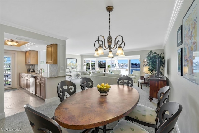 dining space featuring light tile patterned flooring, ornamental molding, a chandelier, and sink