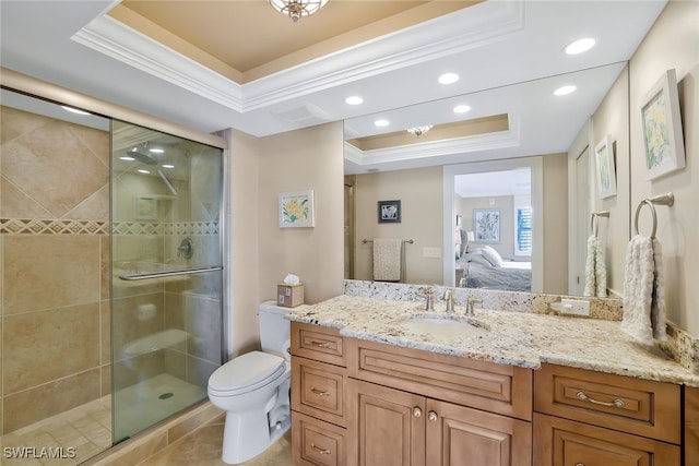 bathroom featuring a tray ceiling, ornamental molding, vanity, toilet, and a shower with door