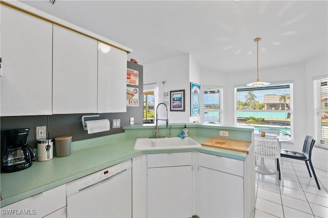 kitchen featuring white dishwasher, sink, white cabinetry, and kitchen peninsula