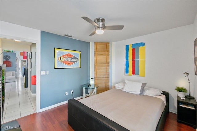 bedroom with dark hardwood / wood-style floors and ceiling fan