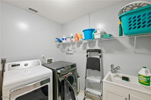 washroom with cabinets and washer and clothes dryer