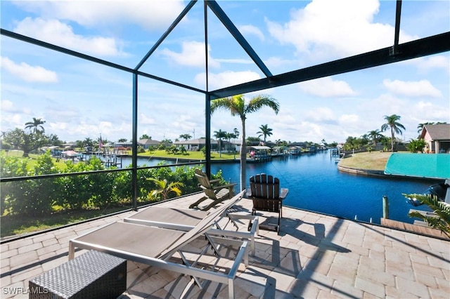 view of patio / terrace featuring a lanai and a water view