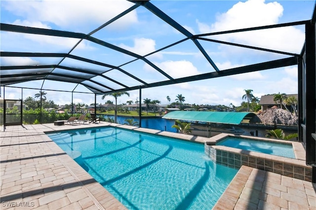 view of pool with a patio, a water view, glass enclosure, and an in ground hot tub