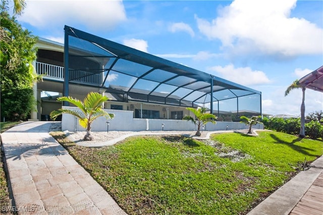 exterior space featuring a lanai and a lawn