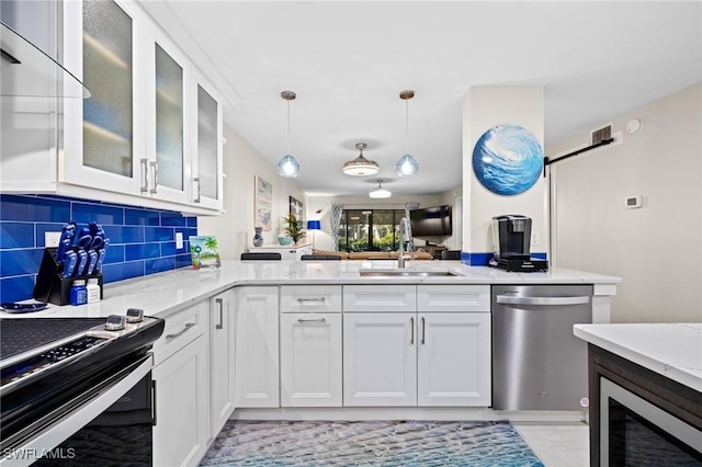 kitchen with stainless steel dishwasher, range with electric stovetop, sink, and white cabinets