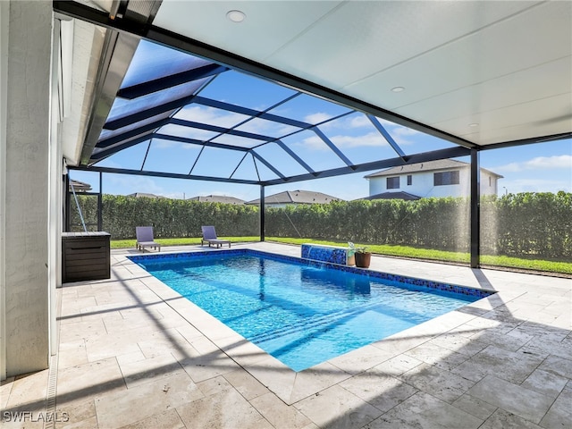 view of swimming pool featuring fence, a lanai, a fenced in pool, and a patio