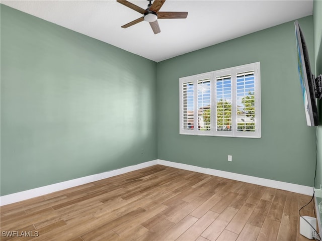 empty room with baseboards, a ceiling fan, and wood finished floors