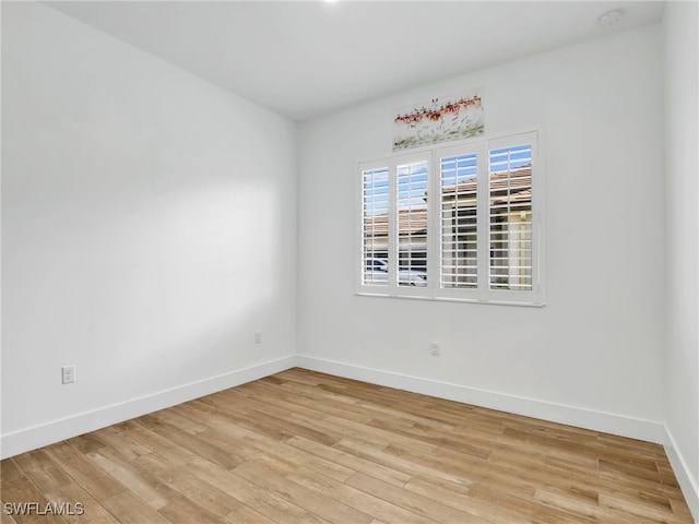 empty room with light wood-style flooring and baseboards
