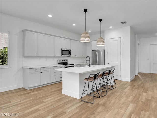 kitchen with light wood-type flooring, stainless steel appliances, and light countertops