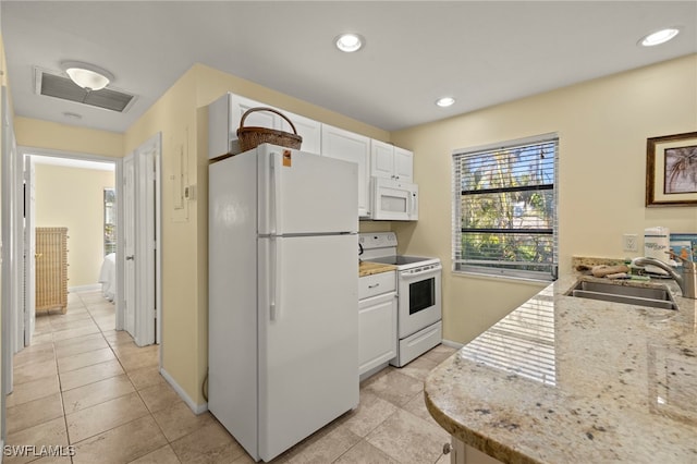 kitchen with sink, white appliances, light stone countertops, and white cabinets