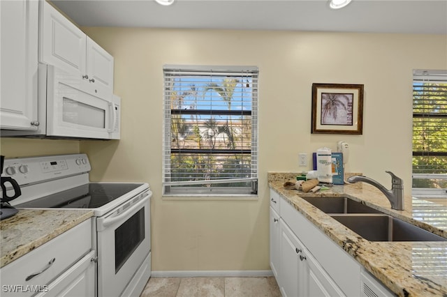 kitchen with white cabinetry, sink, light stone counters, and white appliances