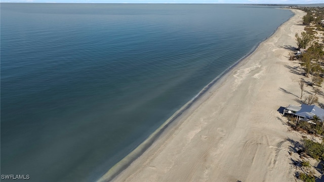 drone / aerial view with a water view and a beach view