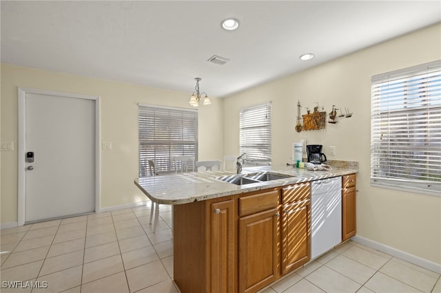 kitchen featuring a wealth of natural light, kitchen peninsula, white dishwasher, and decorative light fixtures