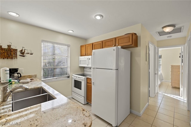 kitchen featuring light tile patterned flooring, white appliances, and sink