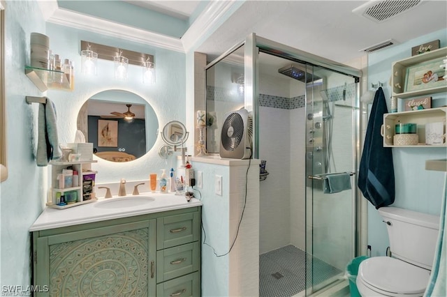 bathroom with toilet, a shower with shower door, ornamental molding, vanity, and ceiling fan