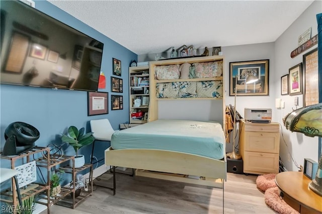 bedroom with light hardwood / wood-style flooring and a textured ceiling