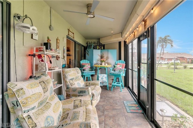 sunroom / solarium featuring ceiling fan