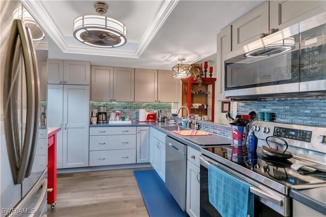 kitchen with sink, gray cabinetry, tasteful backsplash, light hardwood / wood-style flooring, and appliances with stainless steel finishes