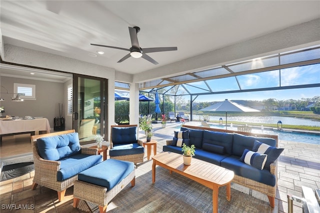 view of patio / terrace with ceiling fan, a swimming pool, outdoor lounge area, glass enclosure, and a water view