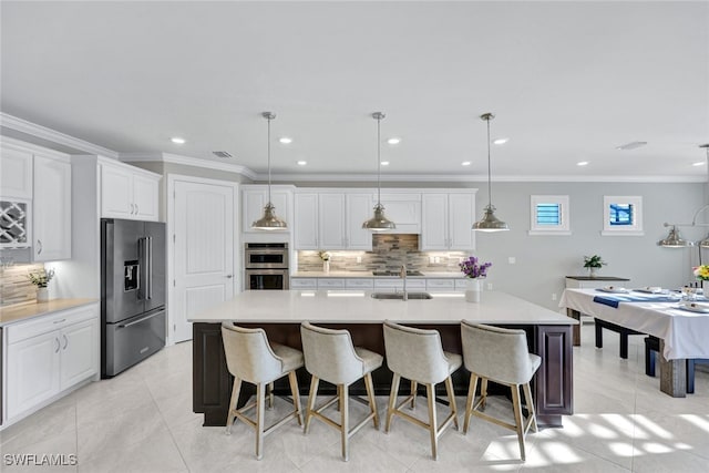 kitchen featuring high quality fridge, a breakfast bar, white cabinetry, hanging light fixtures, and a spacious island