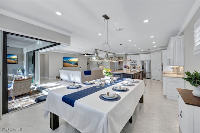 dining space featuring crown molding and sink