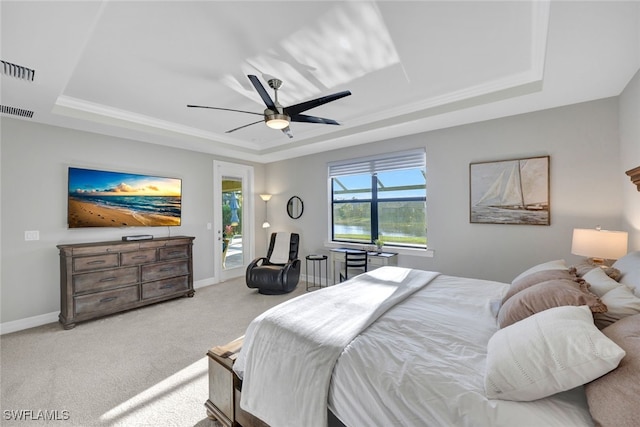 carpeted bedroom with ceiling fan, access to exterior, and a raised ceiling