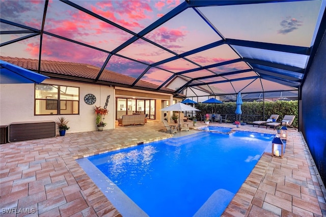 pool at dusk featuring an outdoor living space, a patio, pool water feature, and glass enclosure