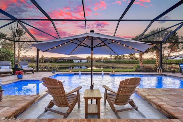 pool at dusk featuring a lanai, a patio, and pool water feature