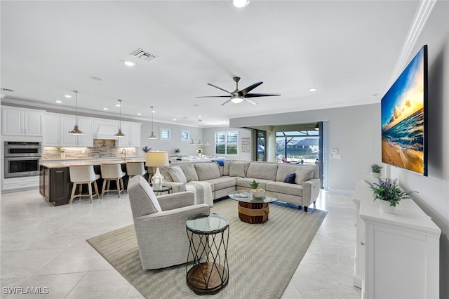 living room featuring crown molding, sink, light tile patterned flooring, and ceiling fan