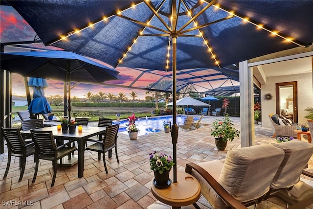 patio terrace at dusk featuring glass enclosure