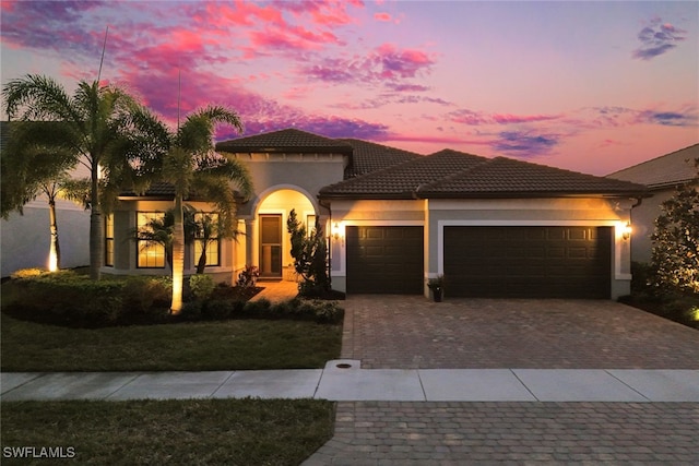 mediterranean / spanish-style home featuring a garage and a lawn